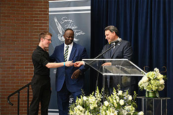 Student receiving scholarship from President Limayem at campus celebration after Inauguration