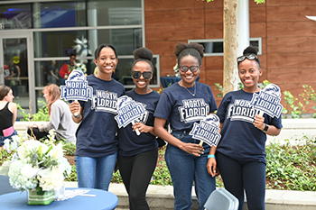 Student holding UNF signs at campus celebration after Inauguration