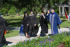 President Limayem and family walking through campus during Inauguration waving at the crowd