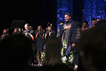 President Limayem at Inauguration on stage with his hand on his chest