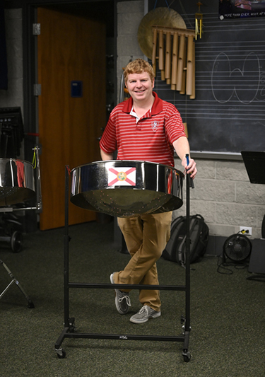 Shaun Bennett standing with a steelpan drum