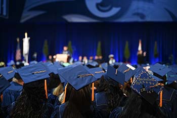 UNF graduates wearing caps and gowns at 2023 commencement ceremony