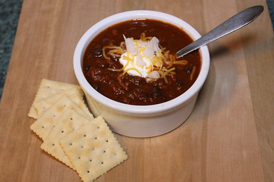 Bowl of chili with crackers on the side