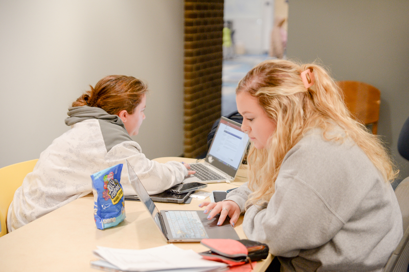 Ladies in the library working on laptops