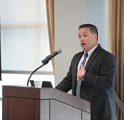 Brian Verkamp speaking at a podium