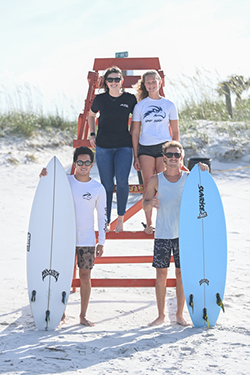 UNF surfers posing on the beach with surfboards