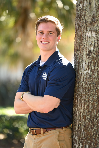 Matthew Doughtery, UNF senior and finance major leaning against a tree