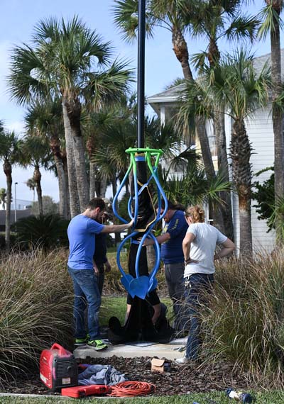 UNF students working to install a sculpture at Jacksonville Beach