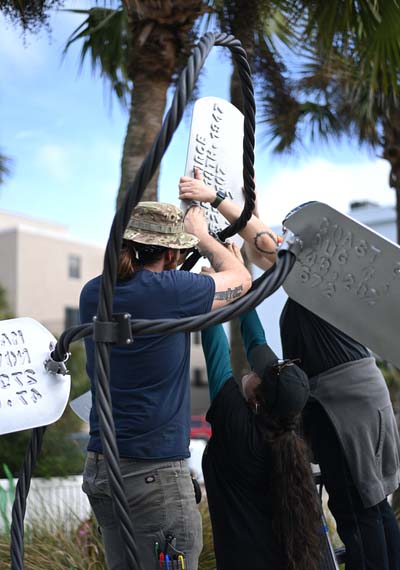 UNF students installing a dog tag sculpture