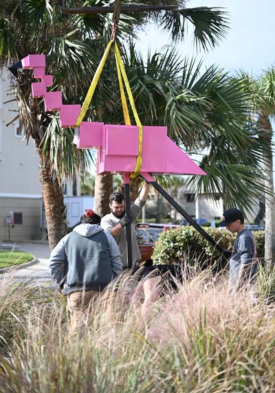 UNF students installing a flamingo sculpture