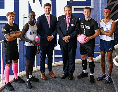 UNF president Moez Limayem and student-athletes wearing pink