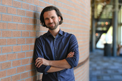 Professor Will Pewitt sitting on stage in the Lazzara Performance Hall