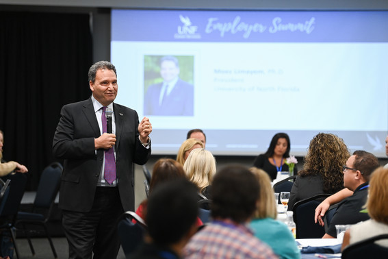 President Limayem speaking in a room full of people