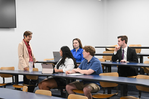 UNF professor speaking with students in a classroom