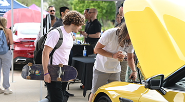 UNF students look at a yellow car during Mercedes-Benz Day
