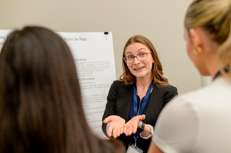 UNF students explains her research to onlookers at the 2024 SOARS Symposium