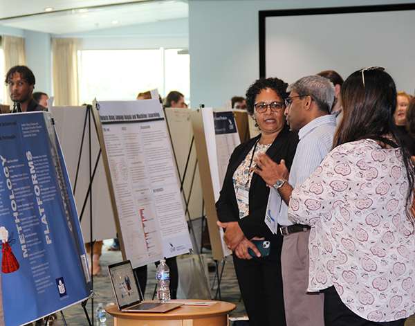 Attendees at a research event looking at a poster