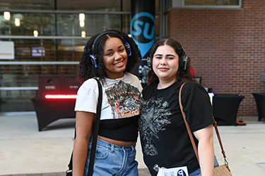 Two female UNF students smiling and posing for a photo