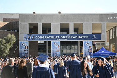 UNF fall 2024 commencement attendees standing outside the UNF Arena