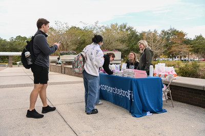 Corporate Traffic Logistics reps passing out coffee and donuts to UNF students
