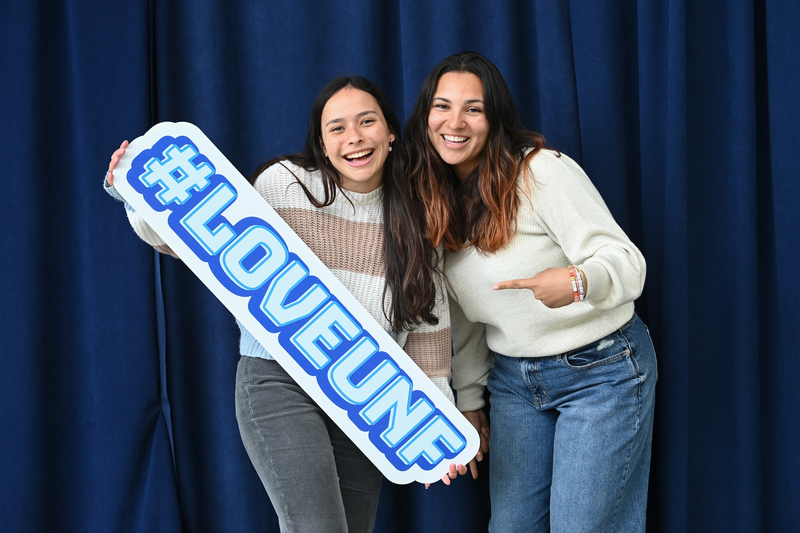 Two female students posing with an #ILoveUNF sign