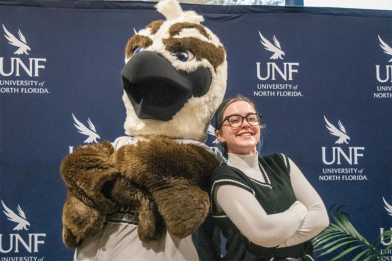 UNF student posing for a photo with Ozzie the Mascot