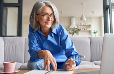 Woman sitting down writing in a notebook