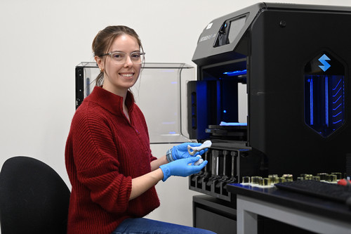 UNF spring 2024 graduate Molly Dubrow holding a knee joint 3D model