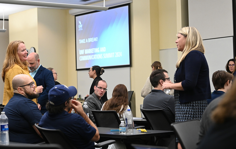 UNF employees conversating with each other at a conference