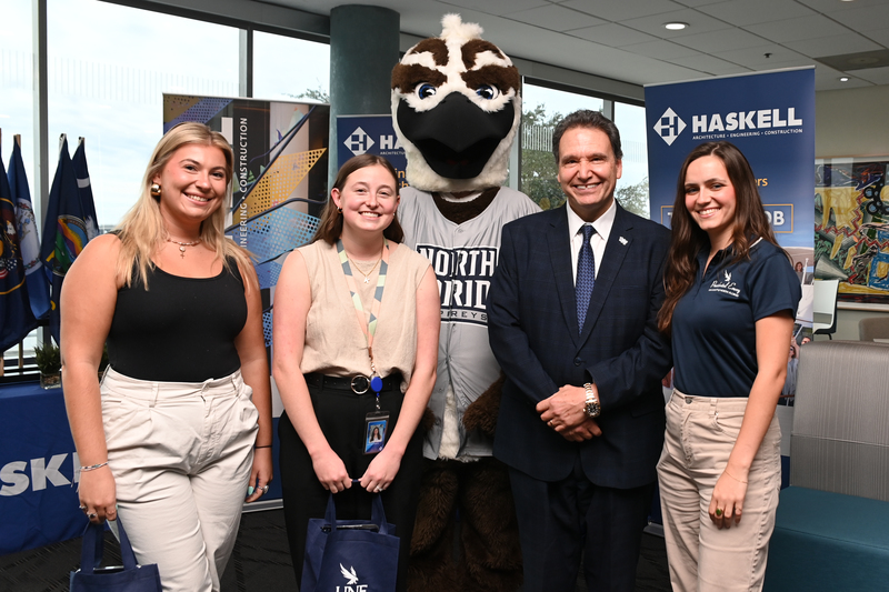 Ozzie and President Limayem visiting Haskell and posing with Haskell employees