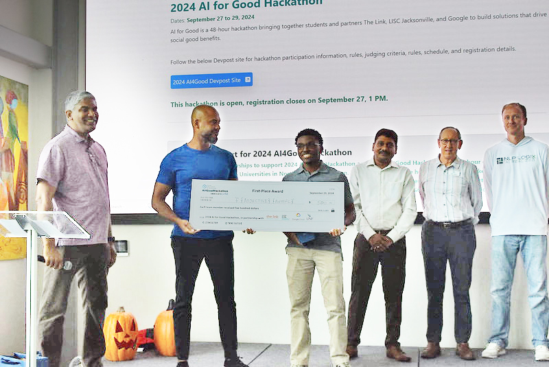 UNF student Marion Forest holding a first-place winner's check at the 2024 AI for Good Hackathon event
