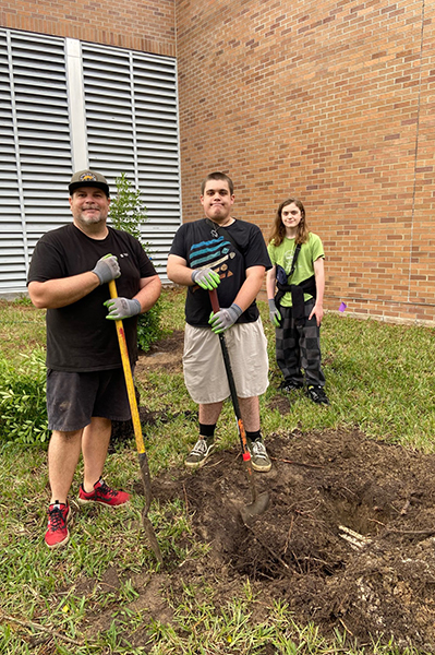 UNF Swoop Into Service volunteers holding shovels standing outside of a building
