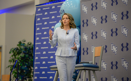 Speaker on stage at the UNF Women's STEM and Athletics Scholarship Luncheon 
