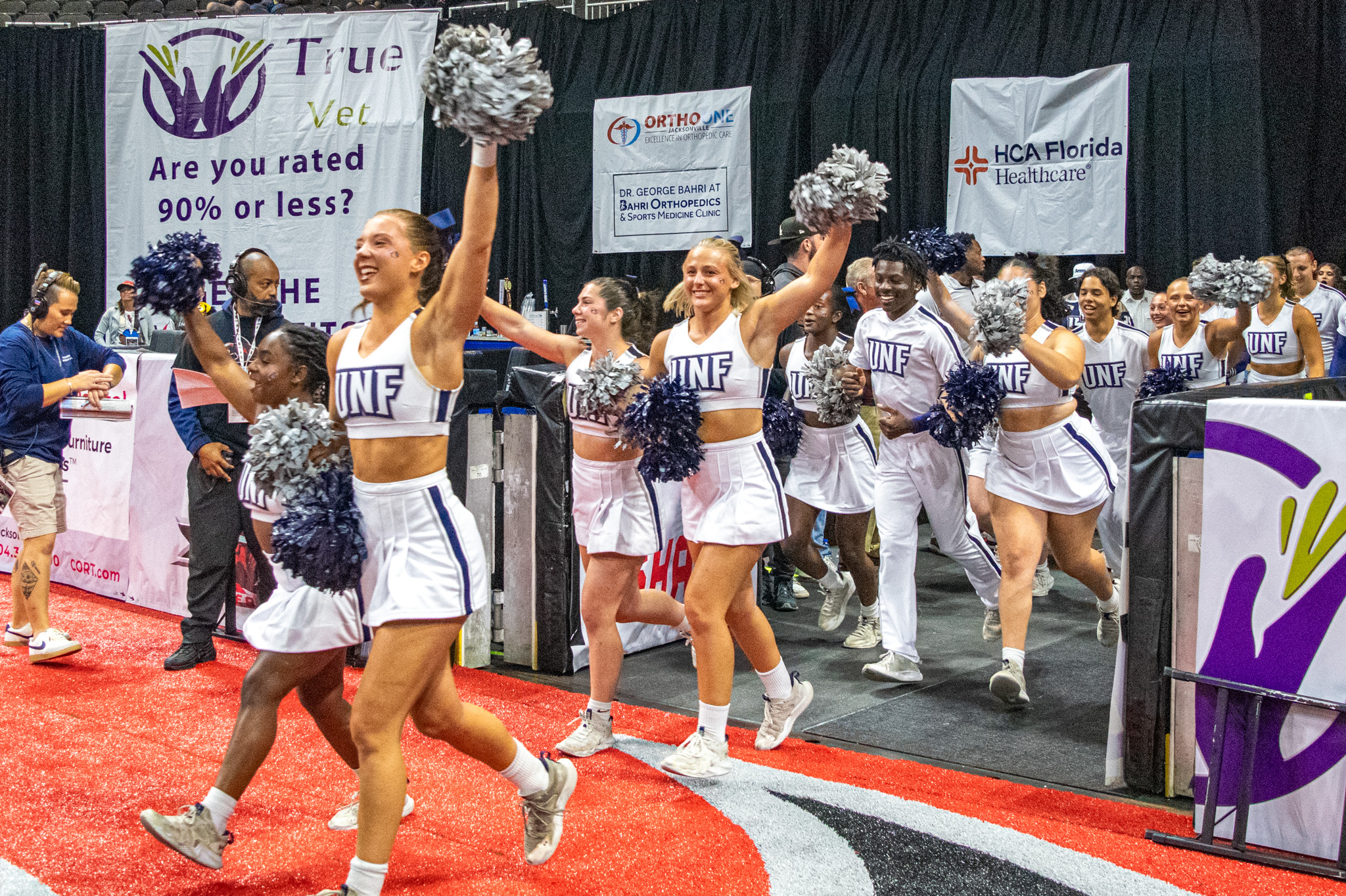 UNF cheerleaders running onto the football field