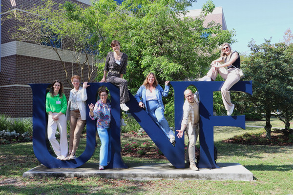 Group of Netherlands educators posing on the large UNF letters