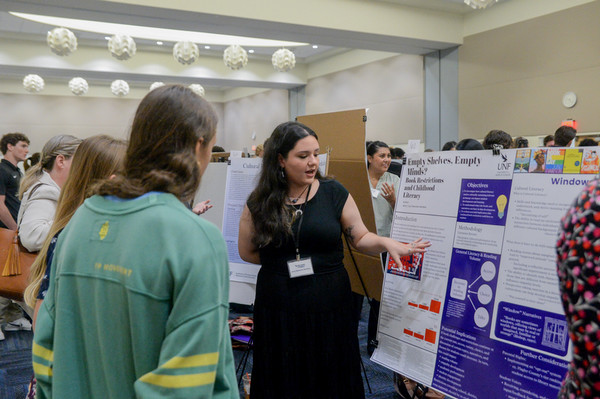 UNF student explaining her research poster