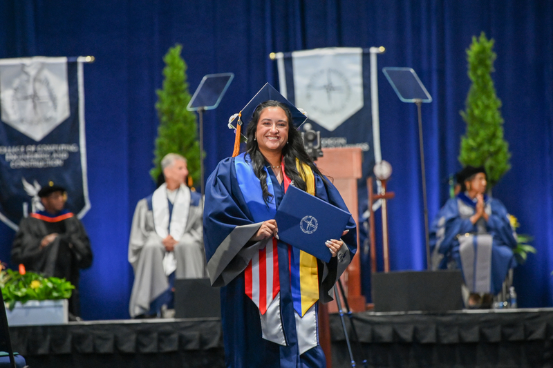 UNF graduates standing at commencement