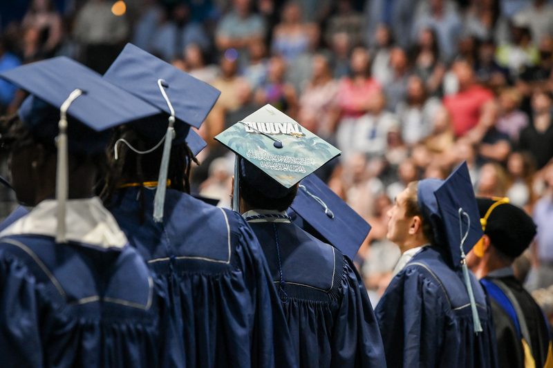 Three graduates posing together in their commencement gowns