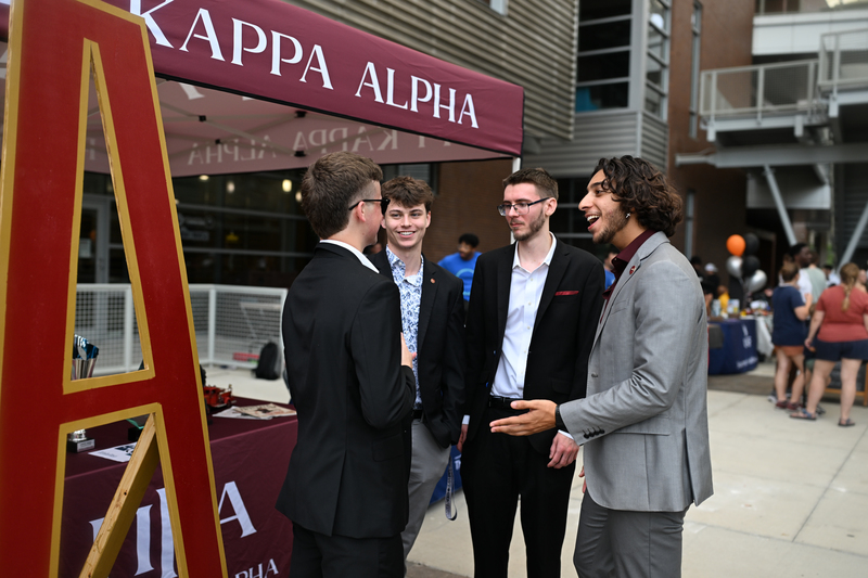 UNF greek chapter students standing in front of a tent