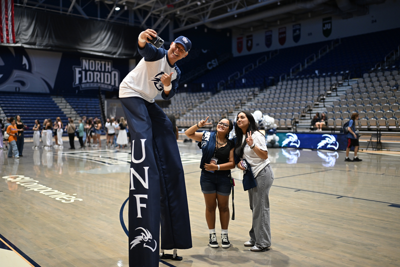 Man taking a selfie with two UNF students