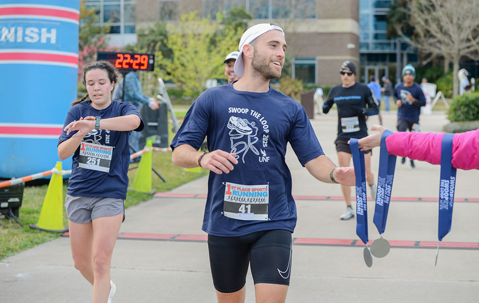 Swoop the Loop 5K participant accepting a participation ribbon