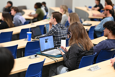 Students in a classroom with their laptops open
