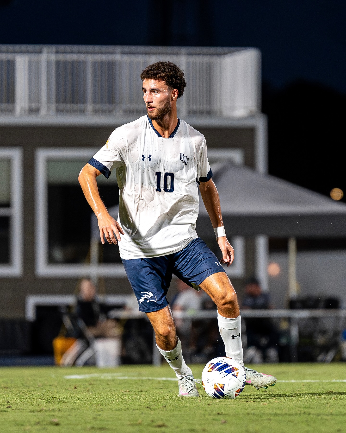 UNF Men's Soccer player kicking the ball during a game