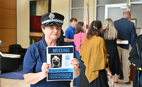 Woman holding a "Missing Ozzie" poster