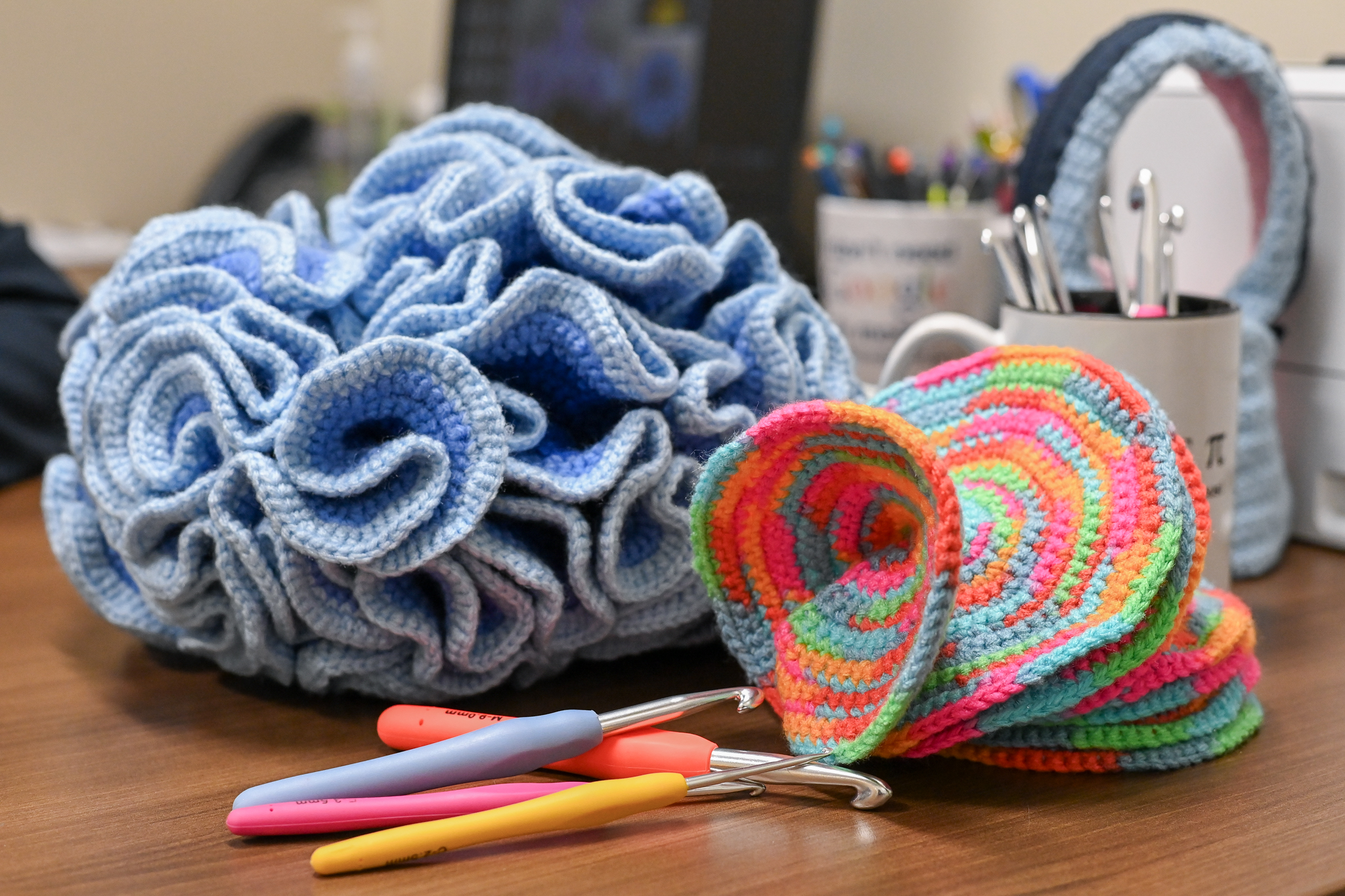 Crochet art pieces on a desk