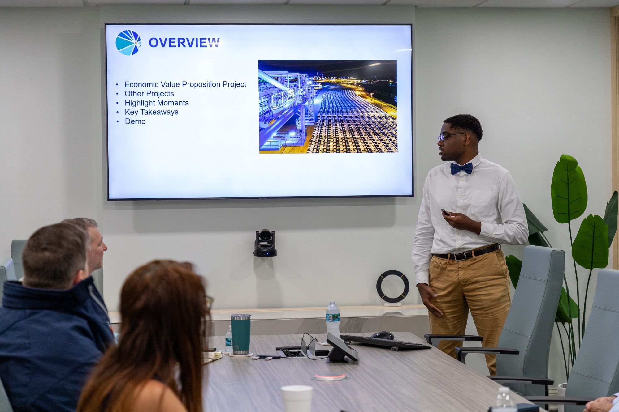 Myers standing in a conference room next to a projector