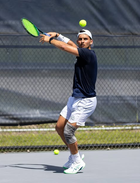 UNF Men's Tennis player swinging racket