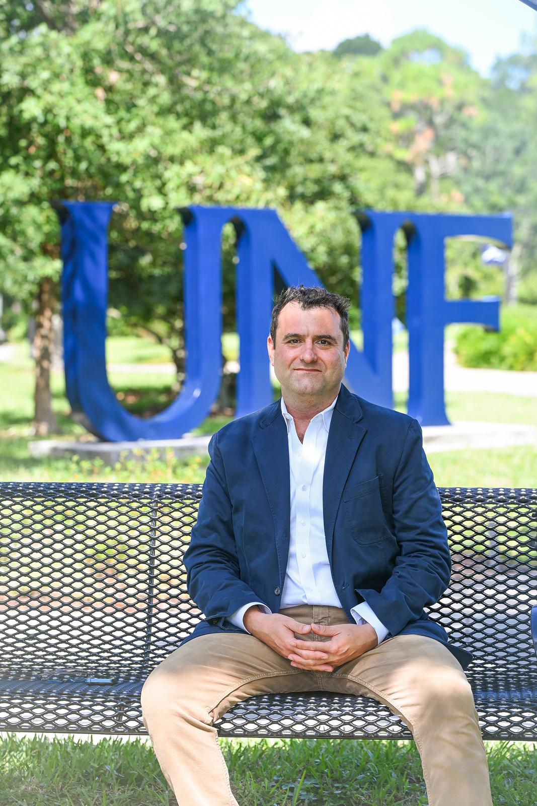 Xavier Rozas sitting on a bench on the UNF campus