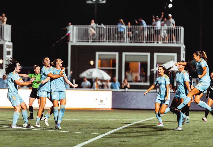 Soccer players running on a field during a game
