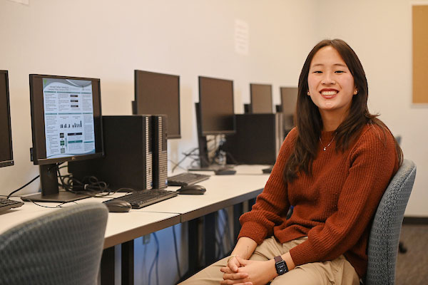 UNF student Ella Luedeke sitting in front of a computer